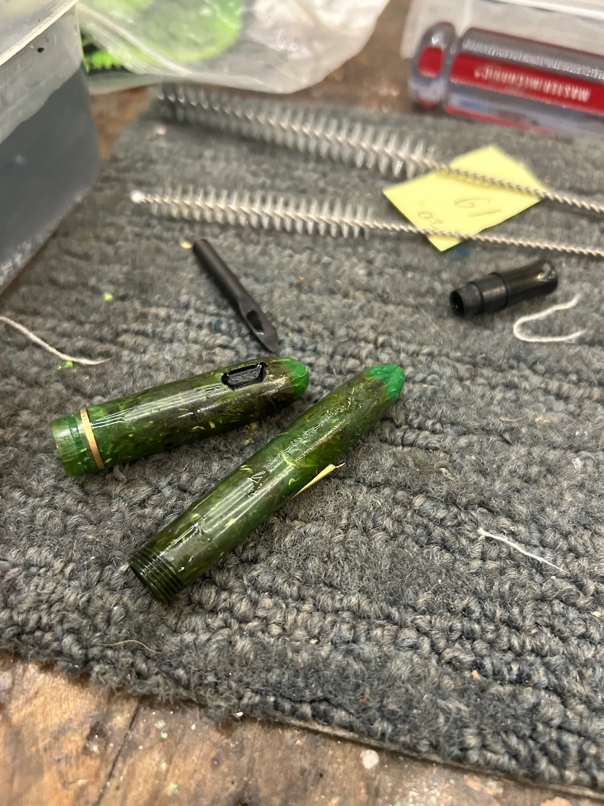 A green marbled pen disassembled, with the cleaning brushes