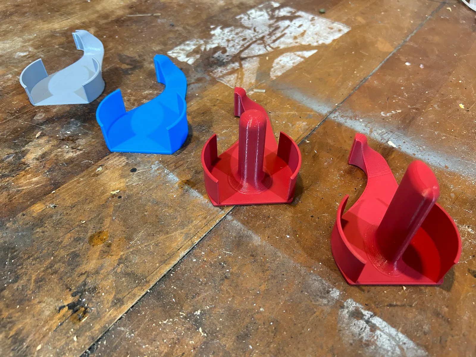 Prints without a handle (gray, blue) beside two with the center handle (red)
