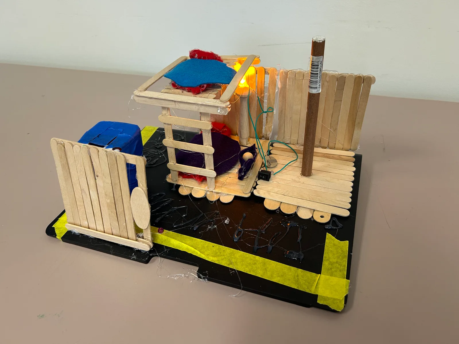 A popsicle-stick cabin with a working door, built over several sessions