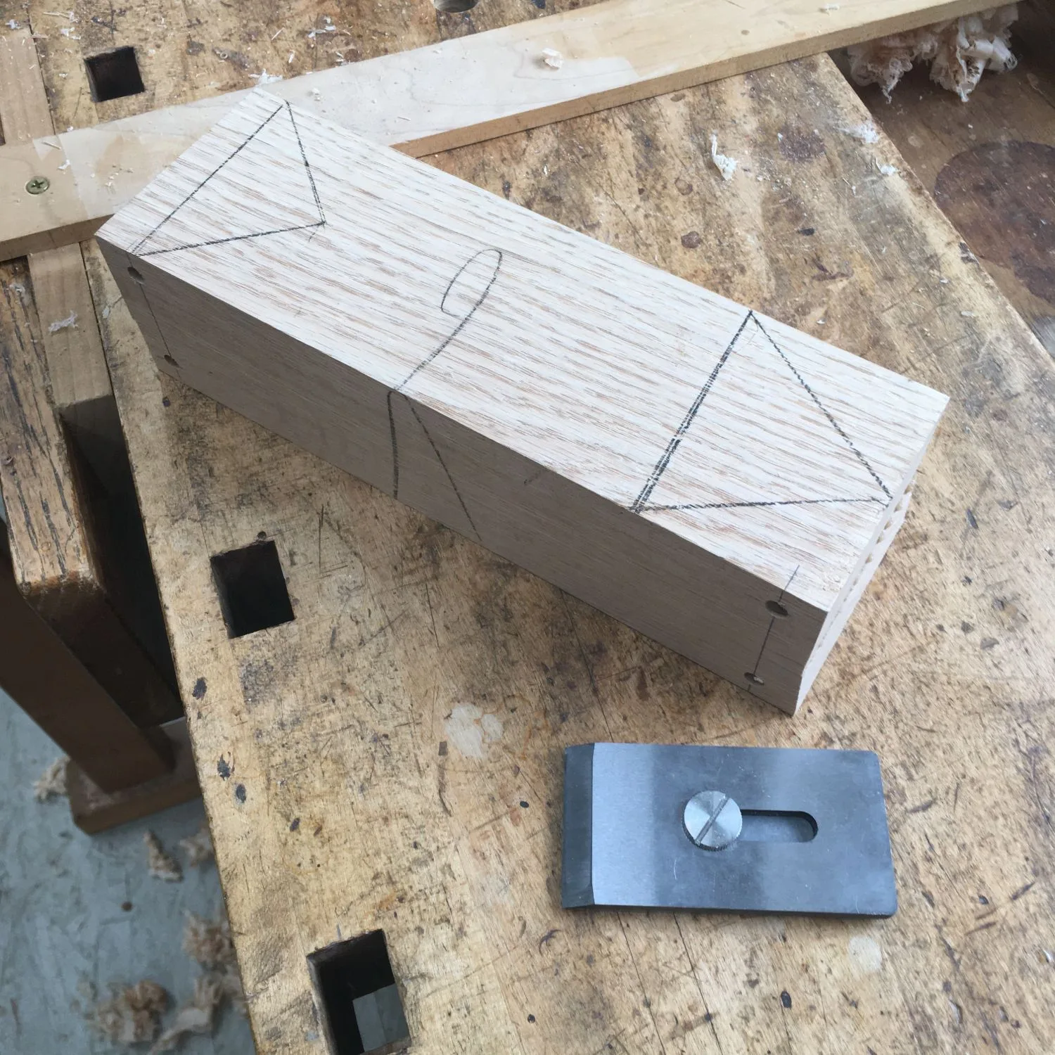 Bed, throat and cross-pin laid out in pencil on the oak blank, next to the iron