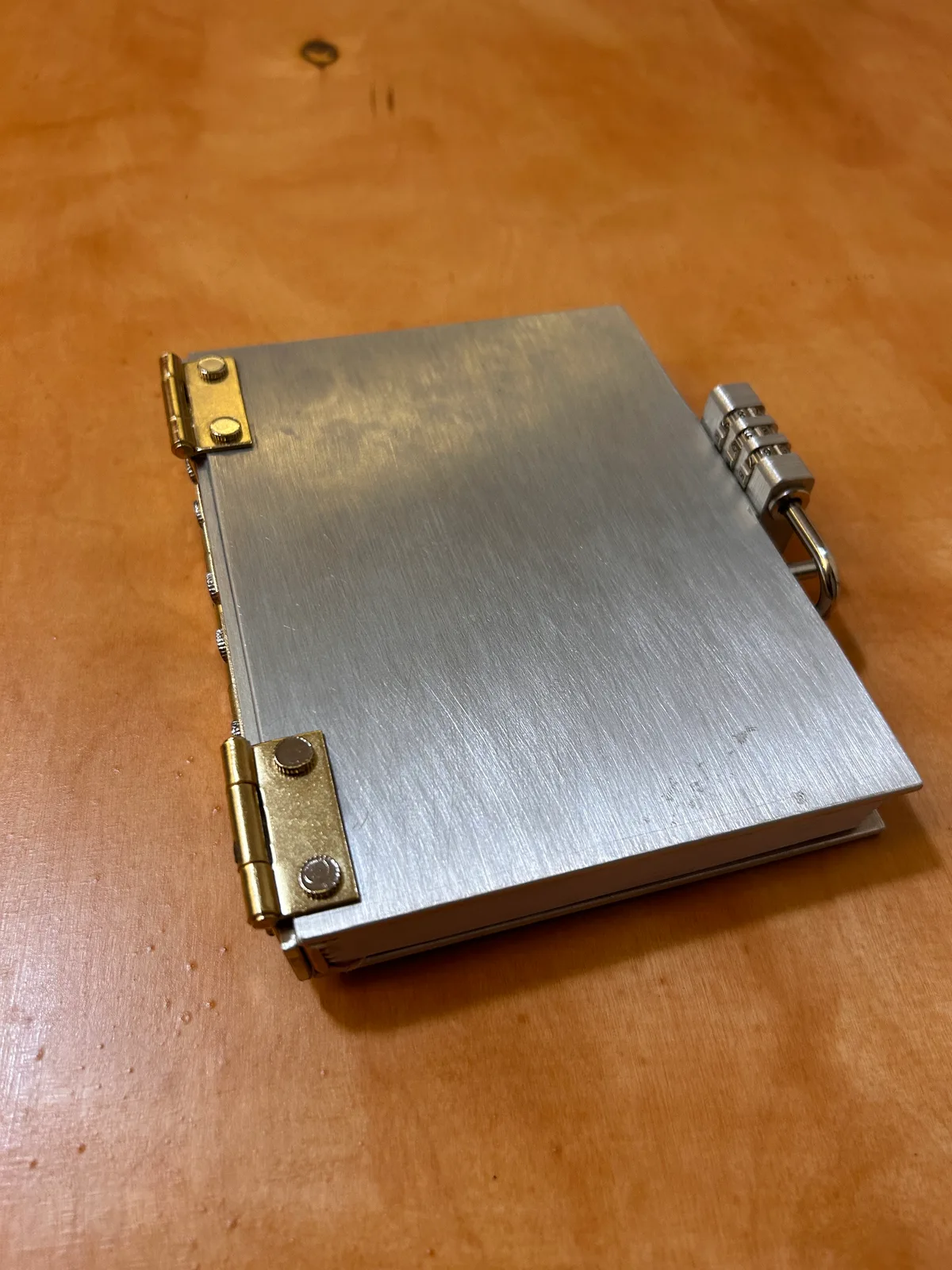 The finished notebook: brushed aluminum, brass hinges and a lock