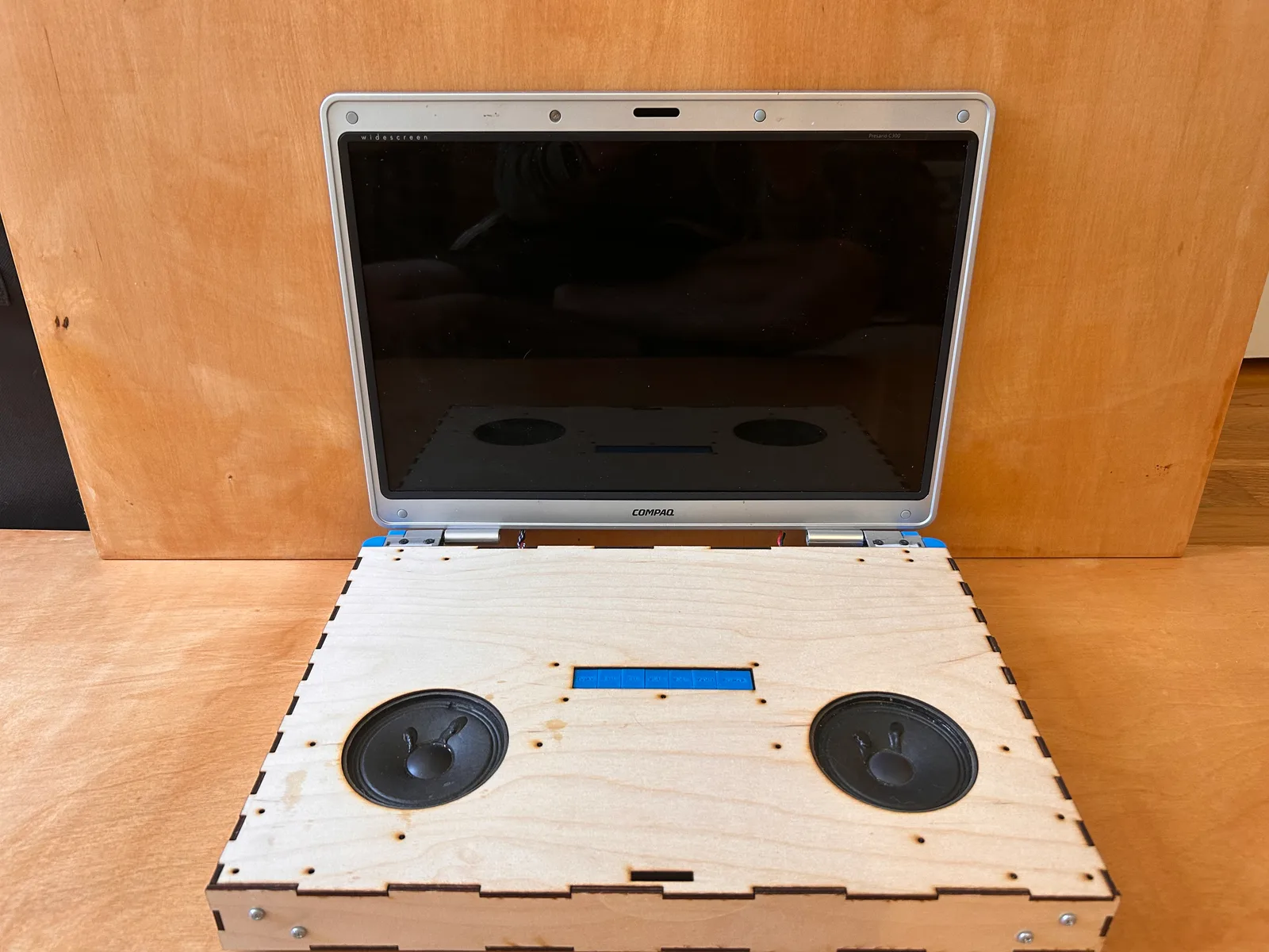 The finished monitor: the laptop's screen with the salvaged speakers set into a plywood base
