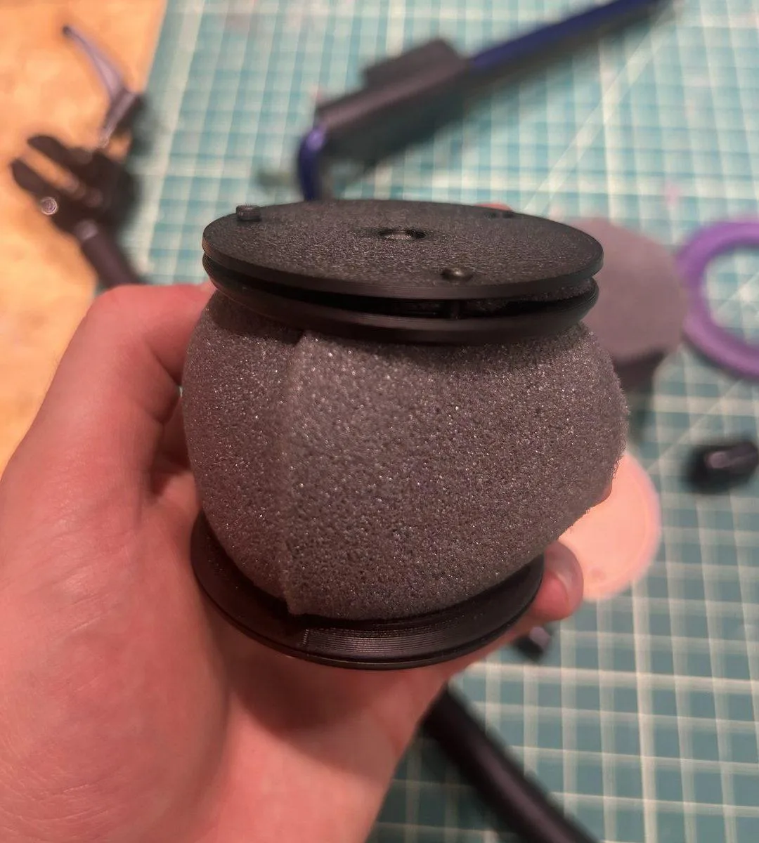 Foam pinched between printed rings at both ends, no glue