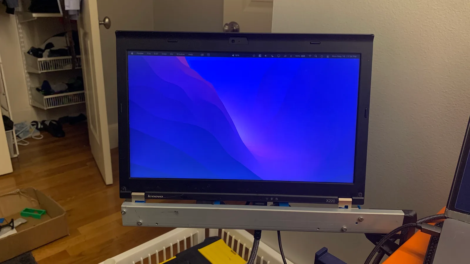 The ThinkPad on its support bar, clamped to the desk