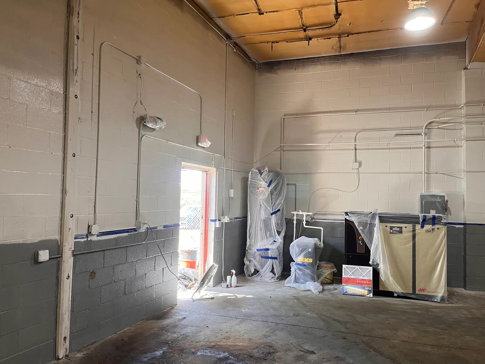 After: the same corner cleared for good; the compressor and tank stayed in place, wrapped while painters repainted the walls.
