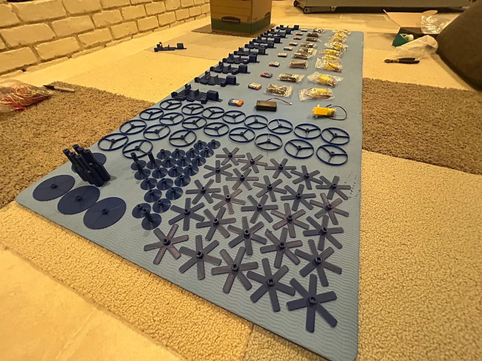 The printed parts for every kit laid out before the party: wheel hubs, discs and chassis pieces