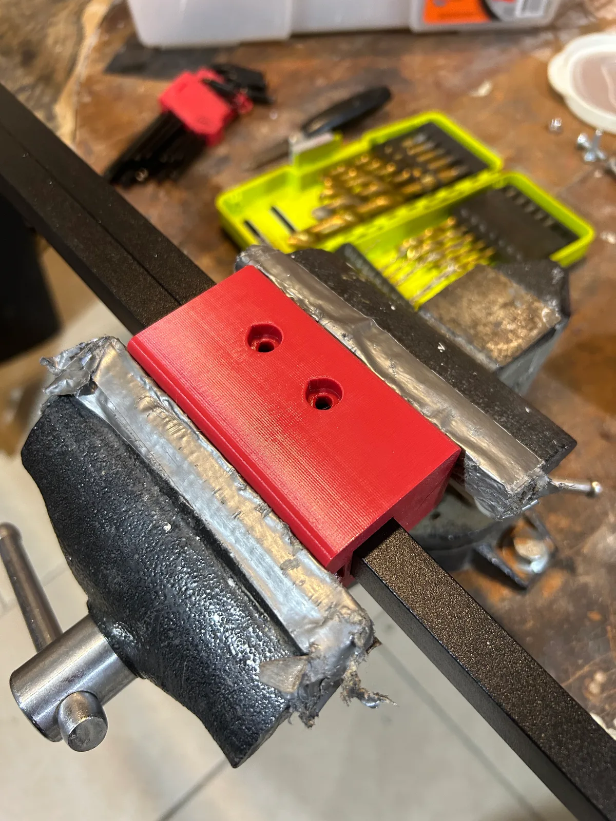 Printed bracket test-fitted on the box extrusion in the vise